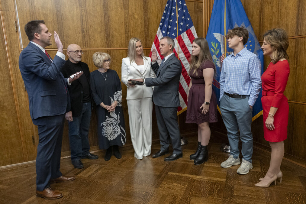  Gov. Kelly Armstrong, center, takes the oath of office administered by Secretary of State Michael Howe on Dec. 13, 2024, He was accompanied by family members and Lt. Gov. Michelle Strinden, right. (Provided by Office of the Governor)